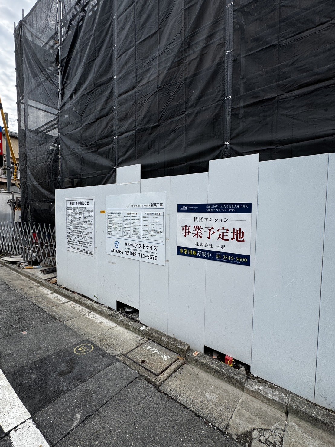 仮囲いに並ぶ建築計画のお知らせ・賃貸マンション事業予定地の掲示
