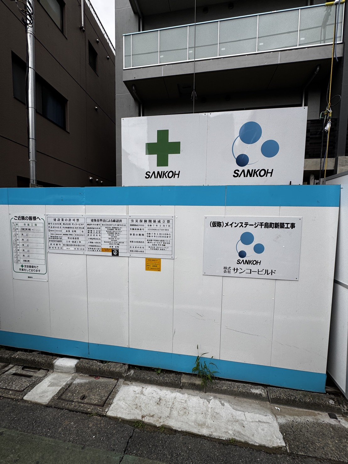 工事現場に掲示された建設業の許可票と施工会社サンコービルドの標識