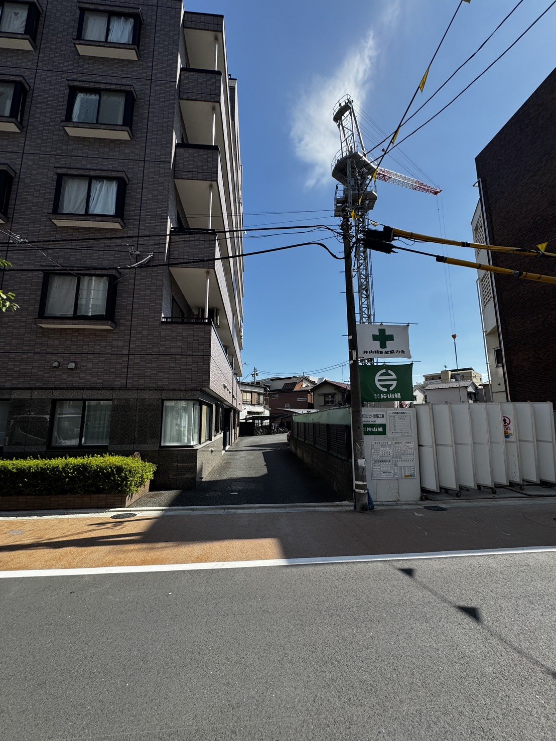 現場へ続く道路沿いの周辺マンションと仮囲い